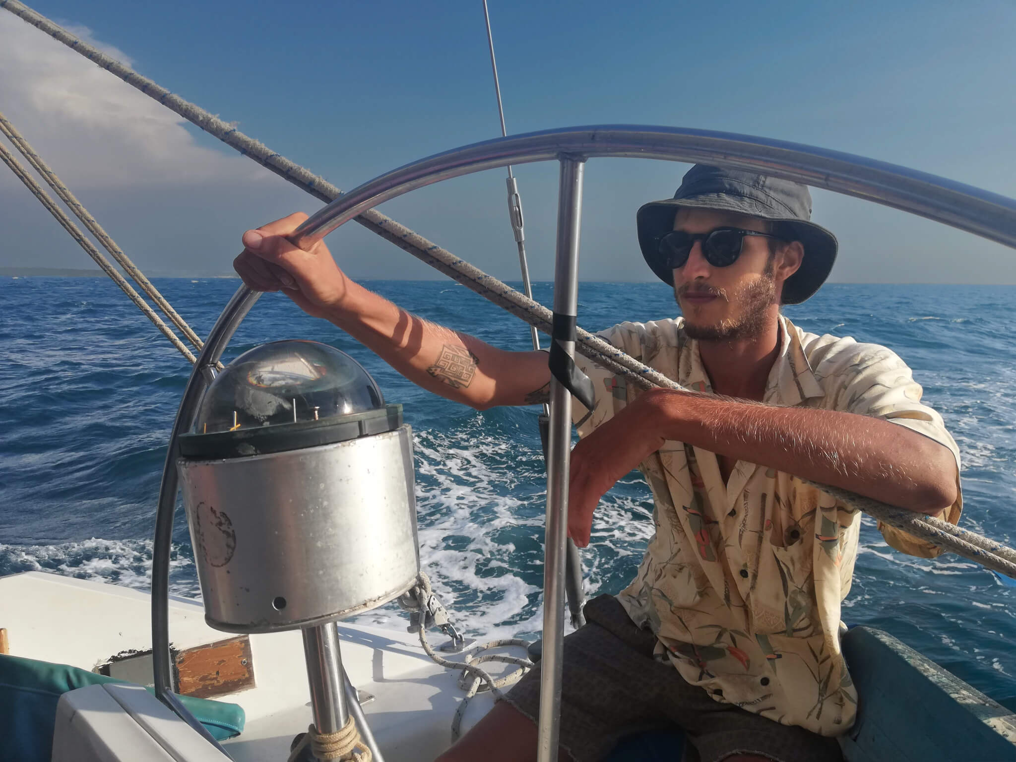 Captain steering a sailboat during early sailing years in the San Blas Islands