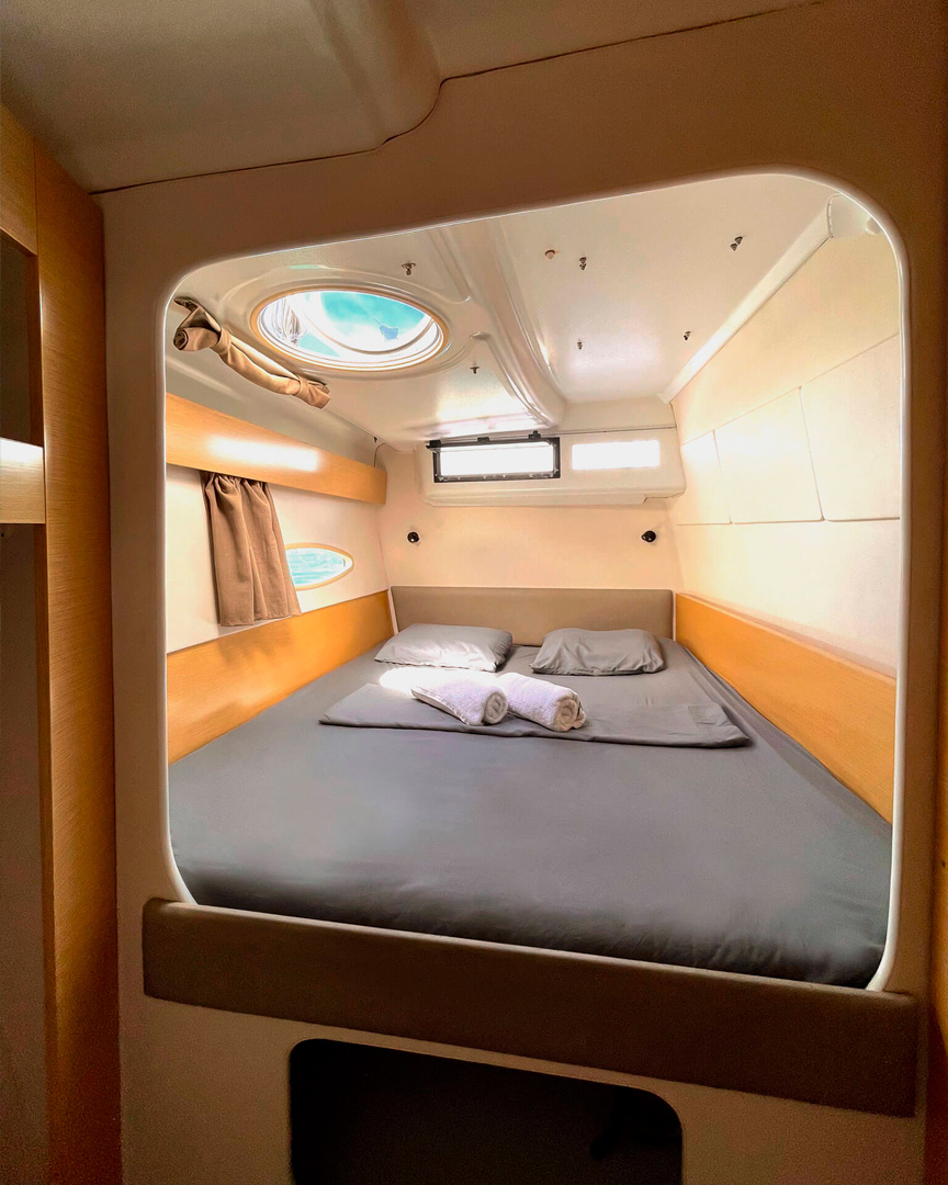 Starboard cabin on Catamaran Atila with comfortable bedding and natural light.