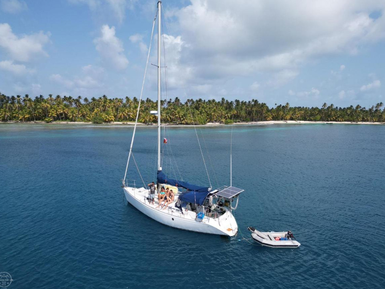 Aerial view of Monohull Maluco sailing in turquoise waters of San Blas, Panama.