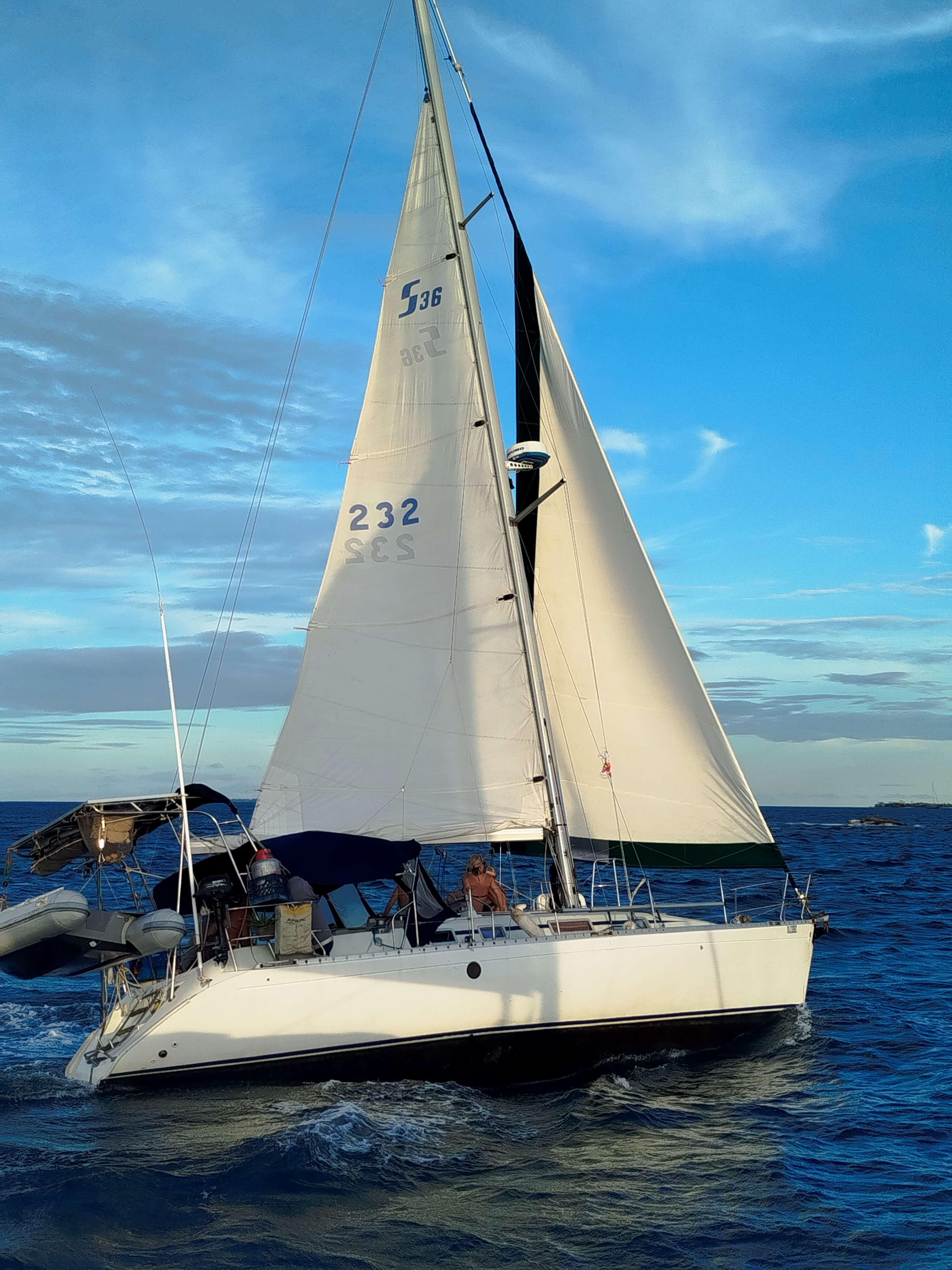 Aerial view of Monohull Maluco sailing in turquoise waters of San Blas, Panama.